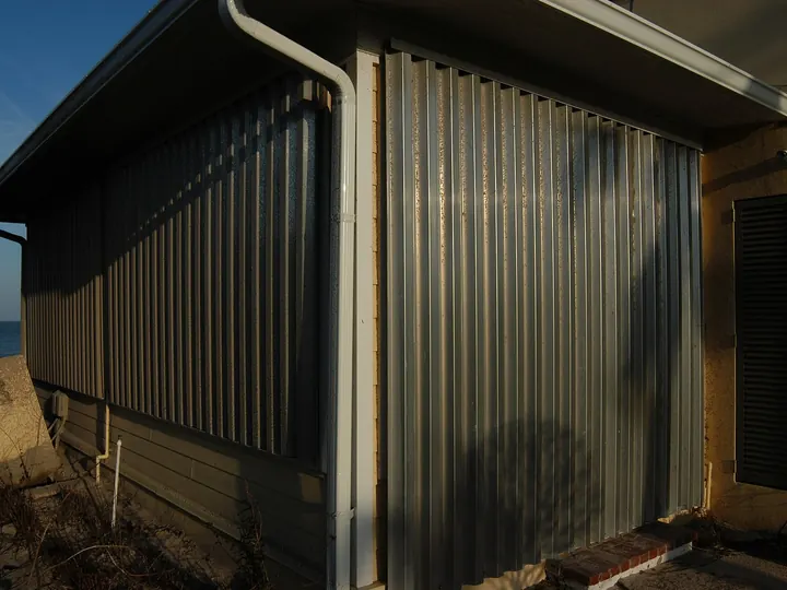 Corrugated aluminum storm panels installed over a window
